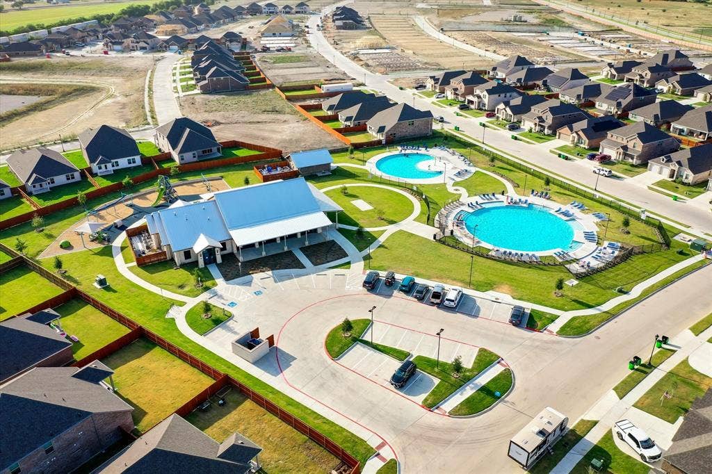 2325 Volans Drive, Haslet, TX 76052 Community clubhouse featuring a covered patio, adjacent circular swimming pools, and a dedicated parking area