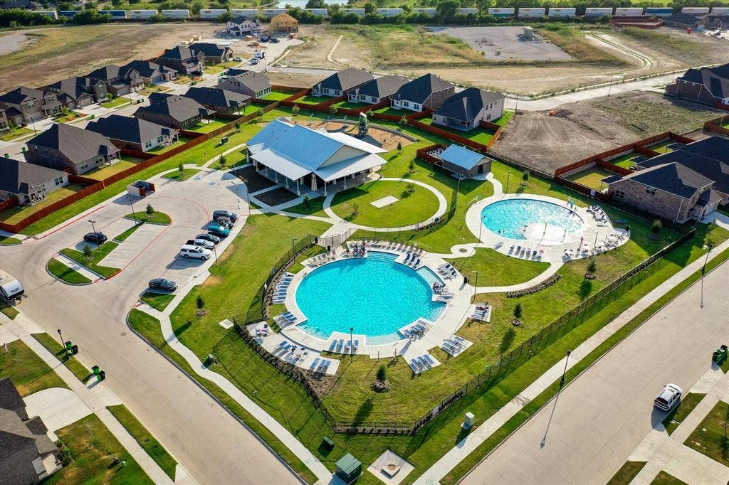 2325 Volans Drive, Haslet, TX 76052 Community amenity area featuring two swimming pools, a covered pavilion, and manicured green spaces