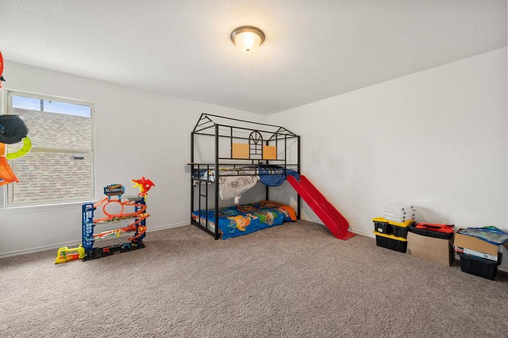 2325 Volans Drive, Haslet, TX 76052 Spacious game room upstairs with plush carpeting and a large window allowing for natural light