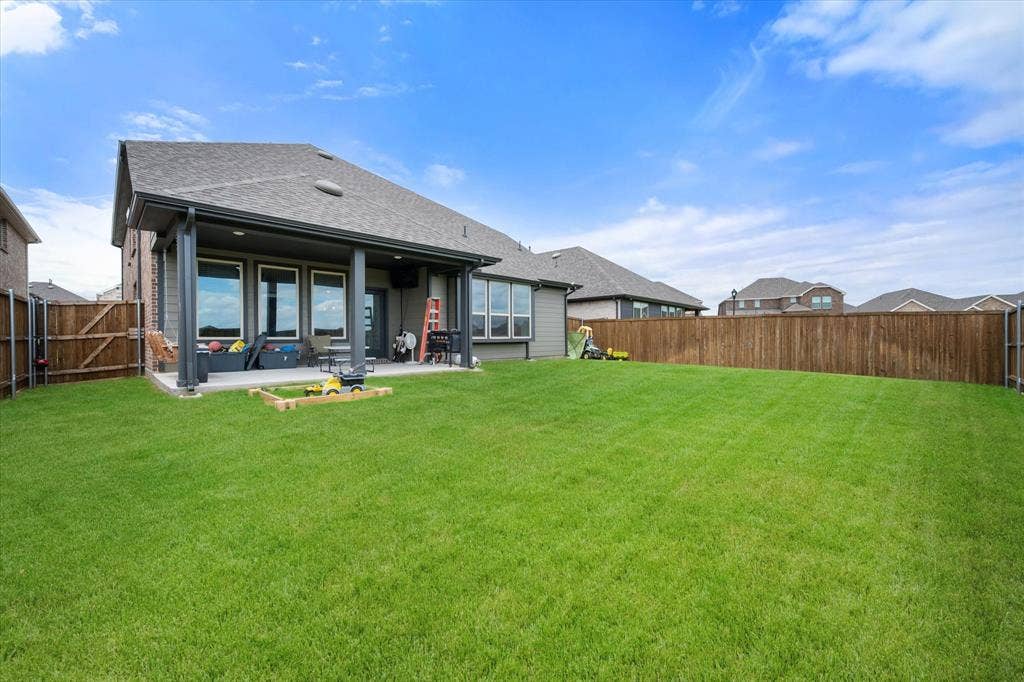 2325 Volans Drive, Haslet, TX 76052 Expansive backyard featuring a covered patio, a large grass lawn, and wood privacy fencing