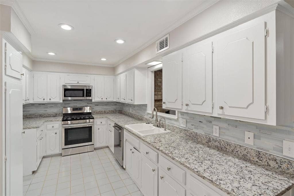 4355 Harvest Hill Road, Dallas, TX 75244 Granite counter tops, tons of storage cabinets and a gas stovetop.