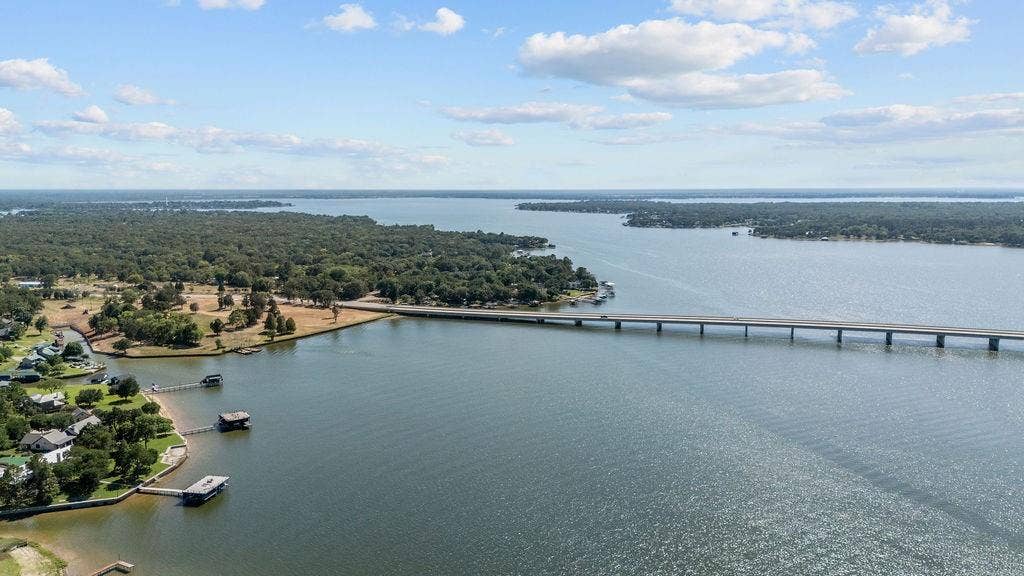 Expansive lakefront property featuring multiple private docks and a shoreline bordered by mature trees