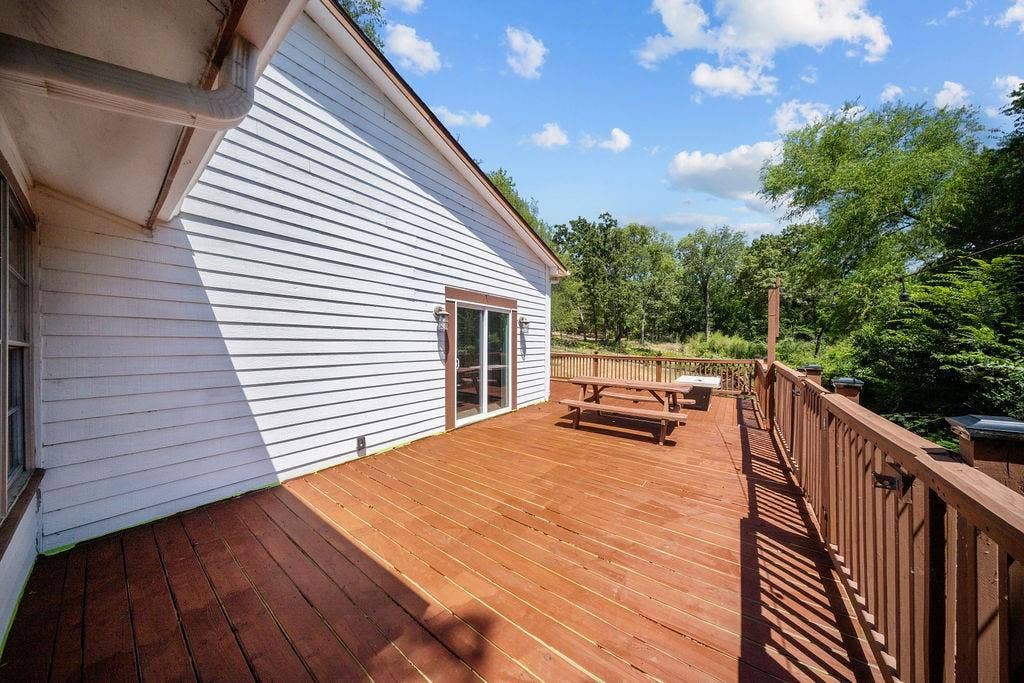Expansive outdoor deck featuring wood-finish flooring and full-height railings