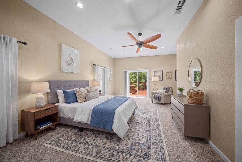 Carpeted room featuring a ceiling fan with wood-finish blades, recessed lighting, and a sliding glass door leading to an outdoor deck