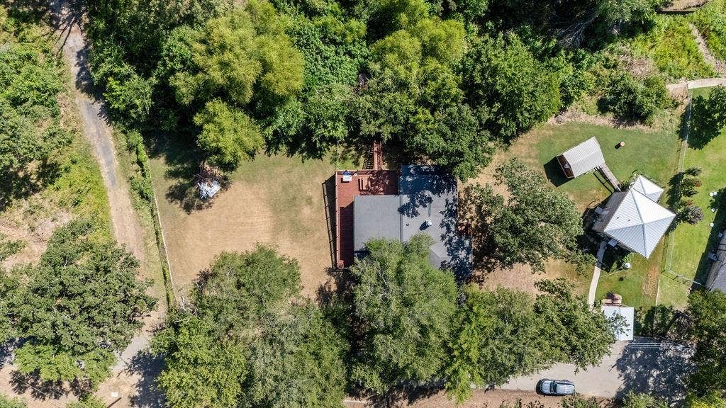 Aerial perspective showcasing the property's expansive lot with mature trees