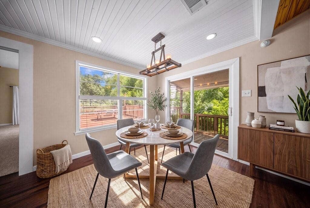 Dining area featuring a paneled ceiling, wood-finish flooring, and a contemporary chandelier