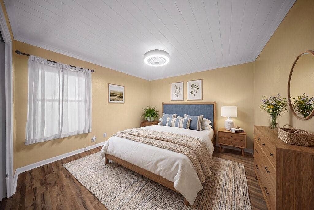 Spacious room featuring wood-finish flooring, a paneled ceiling, and a prominent window with white trim