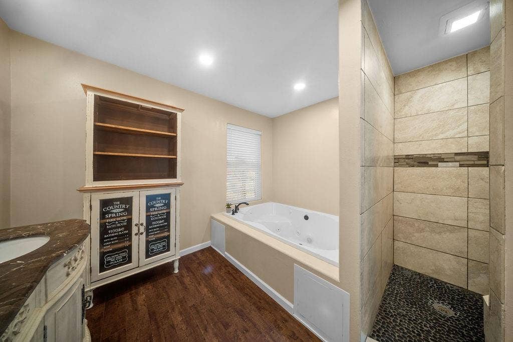 Walk-in shower with pebble tile flooring and decorative accent band
