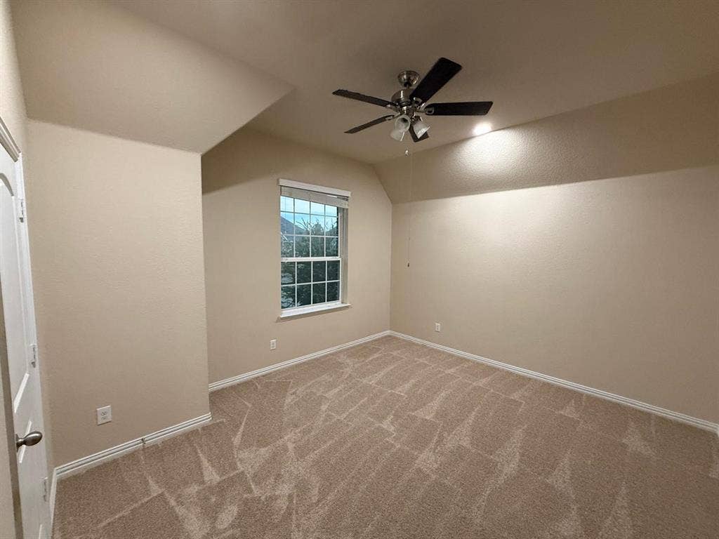 Carpeted room with a ceiling fan, a window with blinds, and neutral wall paint