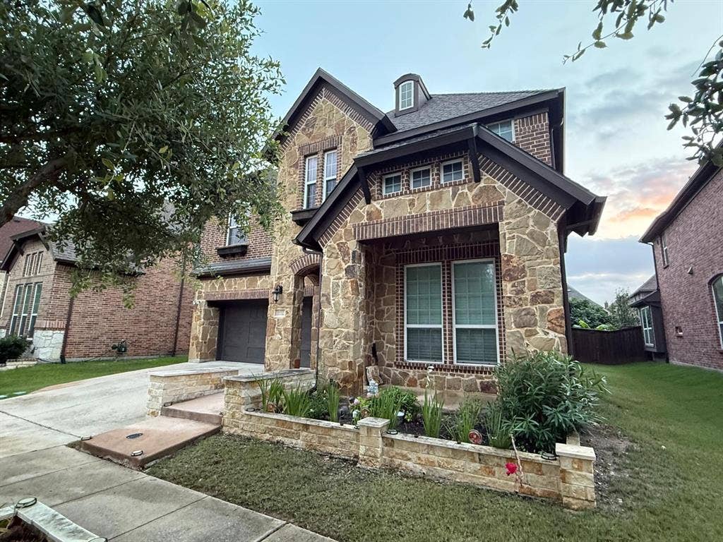 Two-story residence featuring a stone and brick facade