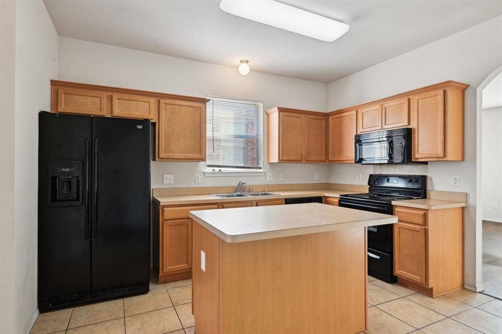 3019 Appaloosa Drive, Dallas, TX 75237 Kitchen featuring light tile patterned flooring, a center island, sink, and black appliances