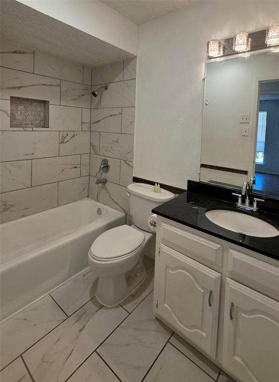 2018 Steamboat Springs Drive, Garland, TX 75044 Bathroom featuring a white bathtub, tiled shower surround with a recessed niche, white vanity with a dark countertop, and a vanity mirror with overhead lighting