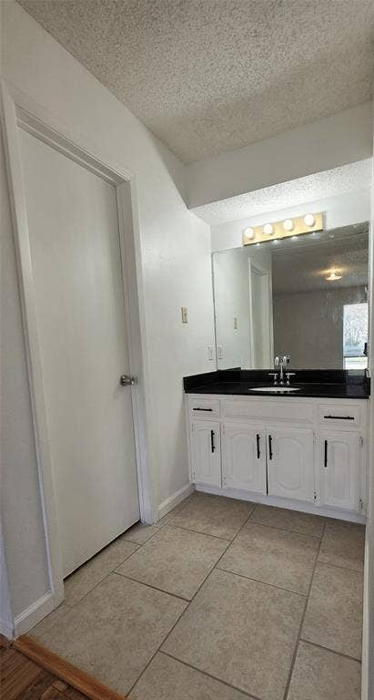 2018 Steamboat Springs Drive, Garland, TX 75044 Vanity featuring a white cabinet with black hardware, a black countertop, and an integrated sink with a chrome faucet