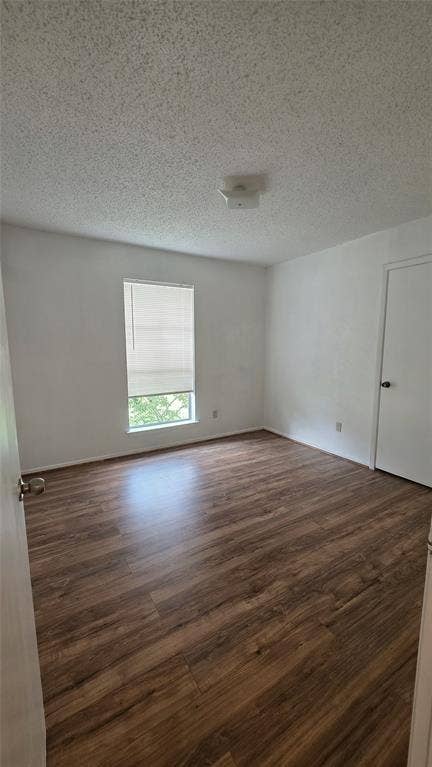 2018 Steamboat Springs Drive, Garland, TX 75044 Spacious room featuring wood-finish flooring, white walls, and a single window with blinds