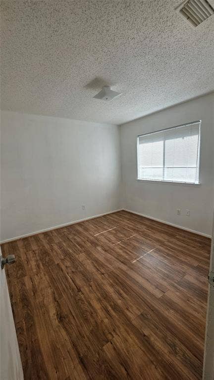 2018 Steamboat Springs Drive, Garland, TX 75044 Spacious room featuring wood-finish flooring, white walls, and a window with horizontal blinds
