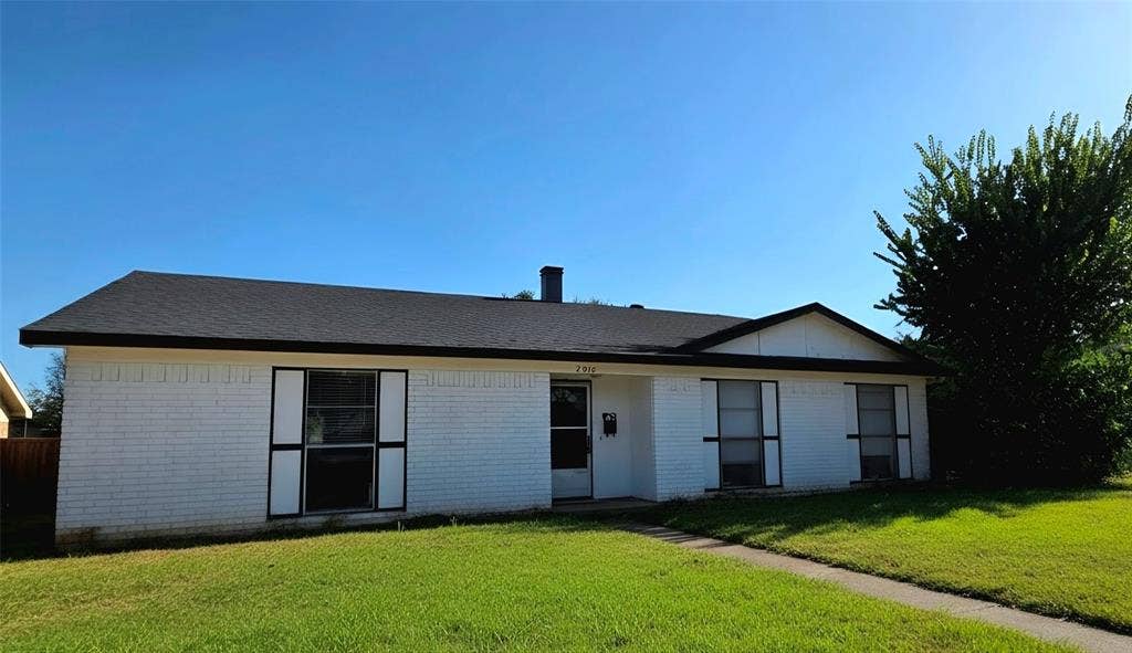 2018 Steamboat Springs Drive, Garland, TX 75044 White brick exterior with a black shingle roof, dark trim, and a concrete walkway