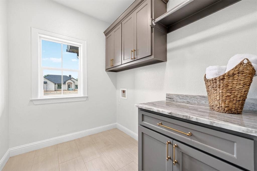 301 Grace Lane, Athens, TX 75751 Utility room featuring upper and lower cabinetry in a gray finish with gold-toned hardware, a light-toned countertop, and wood-finish flooring