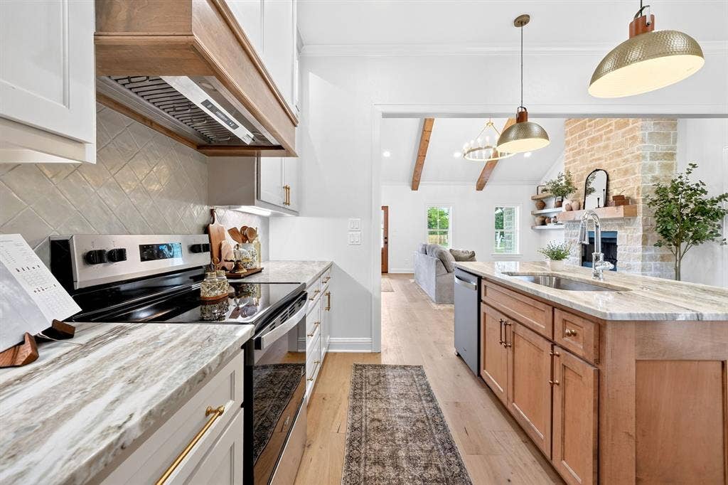 301 Grace Lane, Athens, TX 75751 Kitchen featuring light wood-finish flooring, white perimeter cabinetry with gold hardware, stainless steel range, and a wood-hood range vent