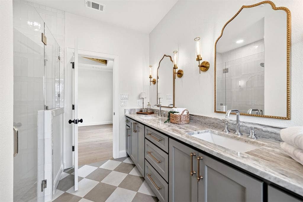 301 Grace Lane, Athens, TX 75751 Dual vanity featuring integrated sinks, a stone countertop, and gray cabinetry with brass hardware