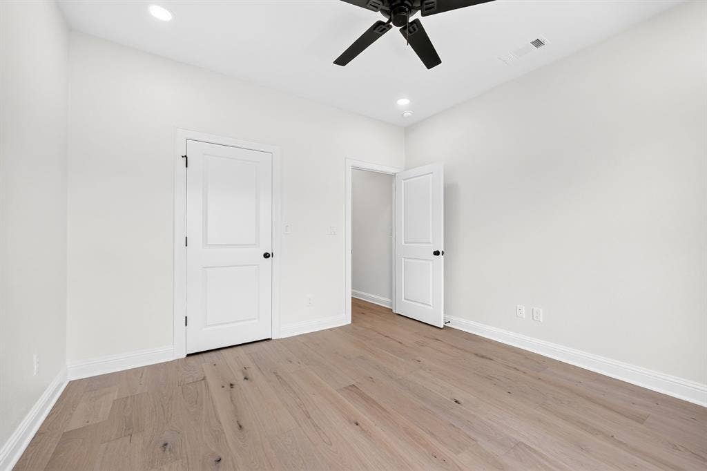 301 Grace Lane, Athens, TX 75751 Spacious room featuring wood-finish flooring, white trim, and a ceiling fan with integrated lighting