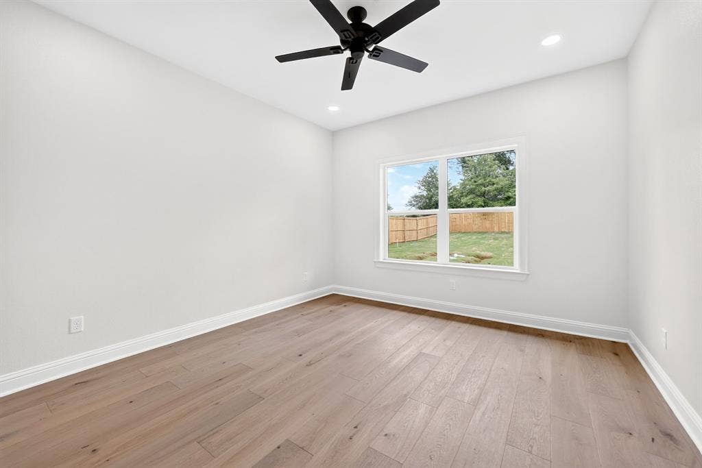 301 Grace Lane, Athens, TX 75751 Light-filled room featuring wood-finish flooring, white baseboards, and a contemporary ceiling fan