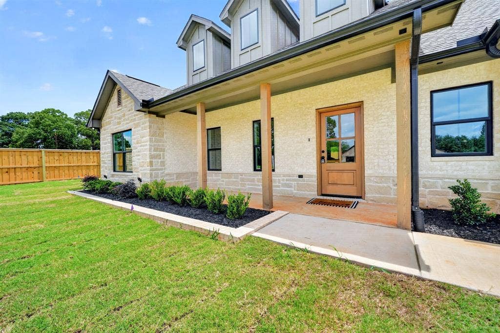 301 Grace Lane, Athens, TX 75751 Exterior featuring stone and stucco finishes, a covered porch with wood columns, and a solid wood entry door with glass panels