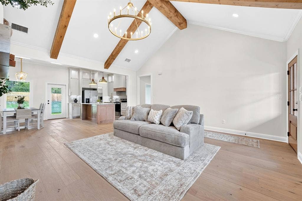 301 Grace Lane, Athens, TX 75751 Vaulted ceiling with exposed wood beams and a large circular chandelier