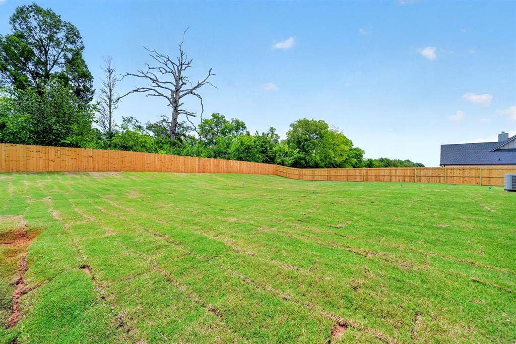 301 Grace Lane, Athens, TX 75751 Expansive backyard featuring a new wood privacy fence, freshly laid sod, and mature perimeter trees