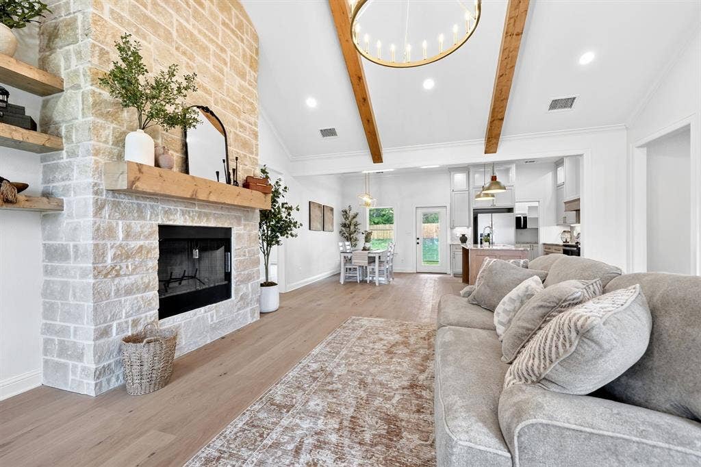 301 Grace Lane, Athens, TX 75751 Spacious living area featuring a stone fireplace with a wood mantle, high vaulted ceilings with exposed wood beams, recessed lighting, and wood-finish flooring