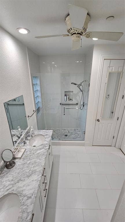 Spacious bathroom featuring a dual vanity with a patterned stone countertop, undermount sinks, and ample storage cabinetry