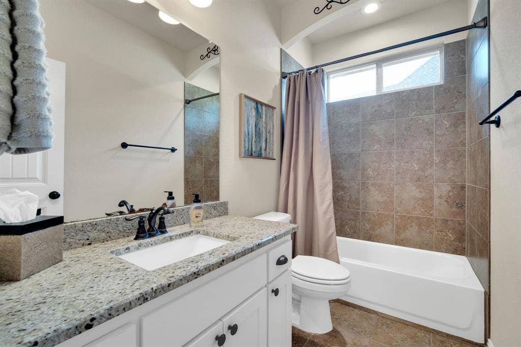 First floor full bathroom. Granite counter top with tile shower tub combonation.