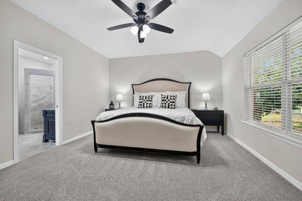 Spacious room featuring vaulted ceilings and neutral-toned carpeting