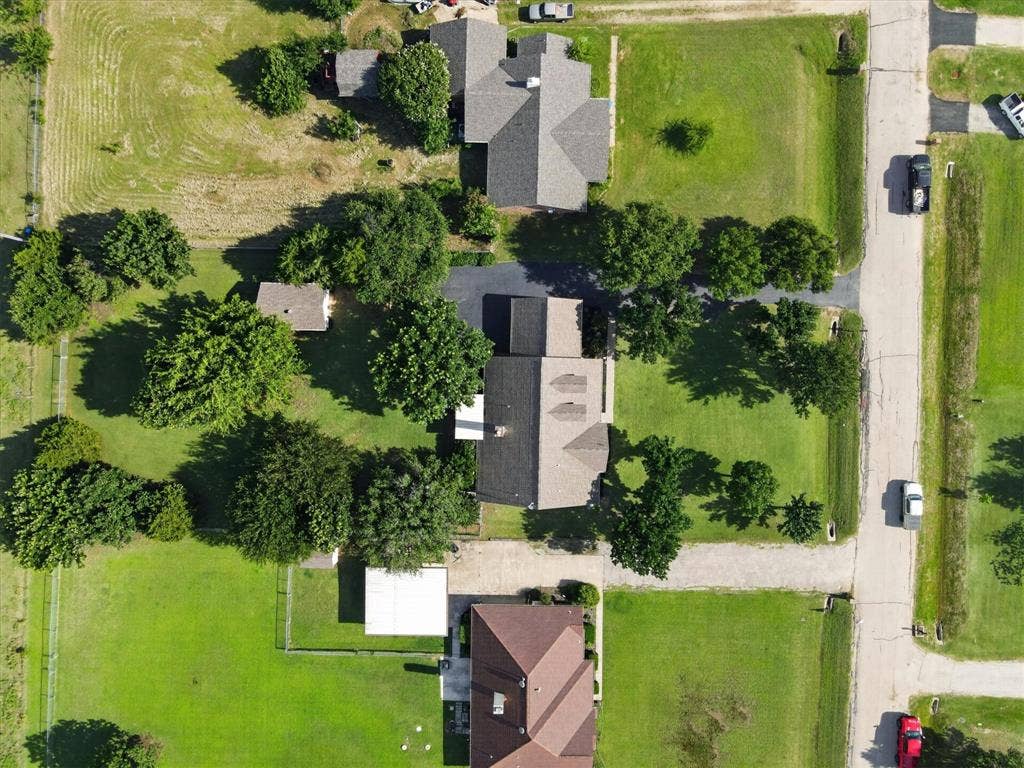 Aerial perspective showcasing multiple properties with extensive green lawns and mature trees
