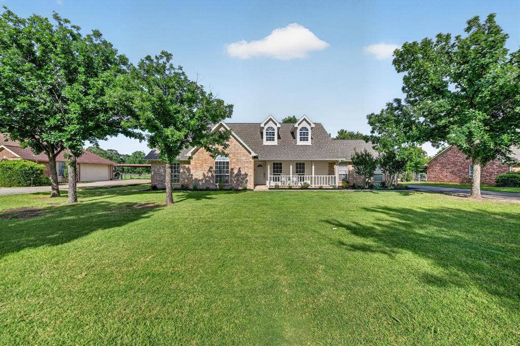 Spacious front lawn with mature trees