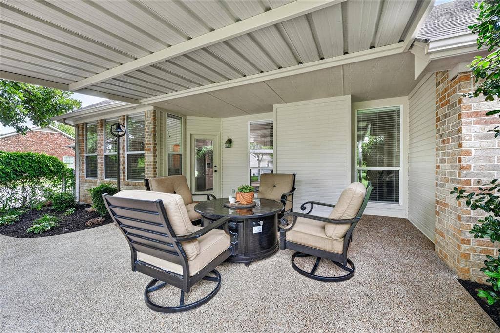 Covered outdoor patio area featuring a textured concrete surface and a solid roof