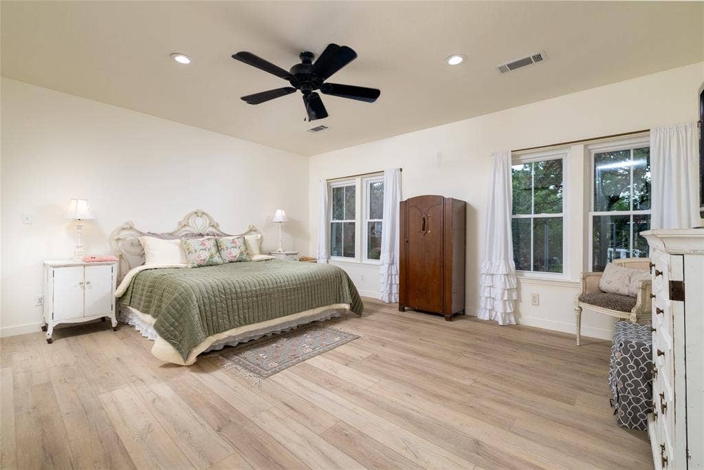 Spacious room featuring light wood-finish flooring, recessed lighting, and a ceiling fan