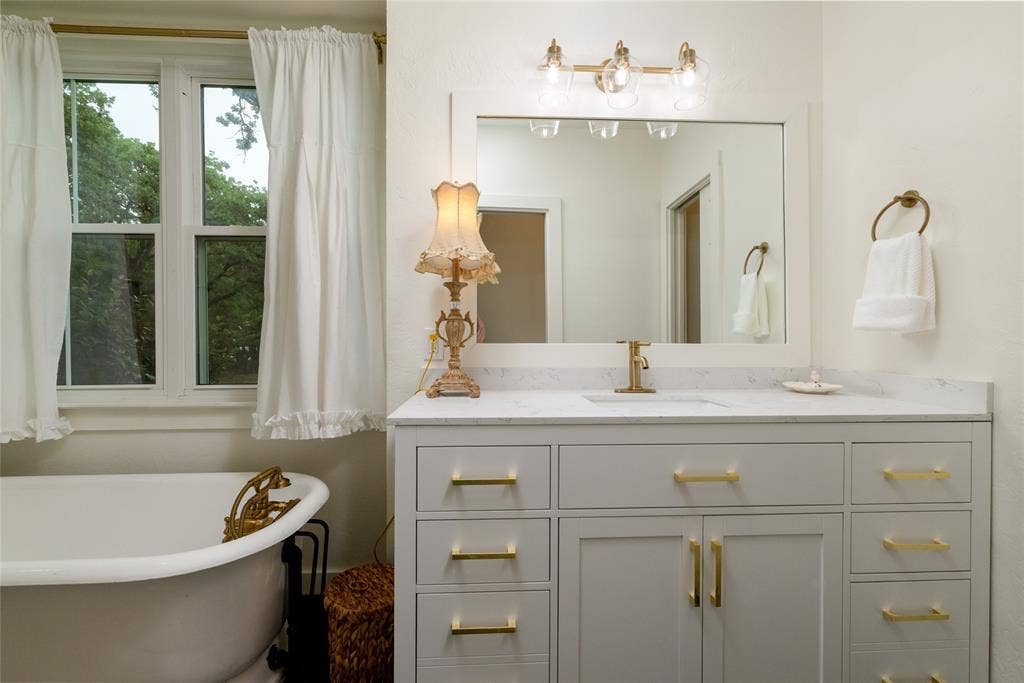 White clawfoot tub with brass fixtures