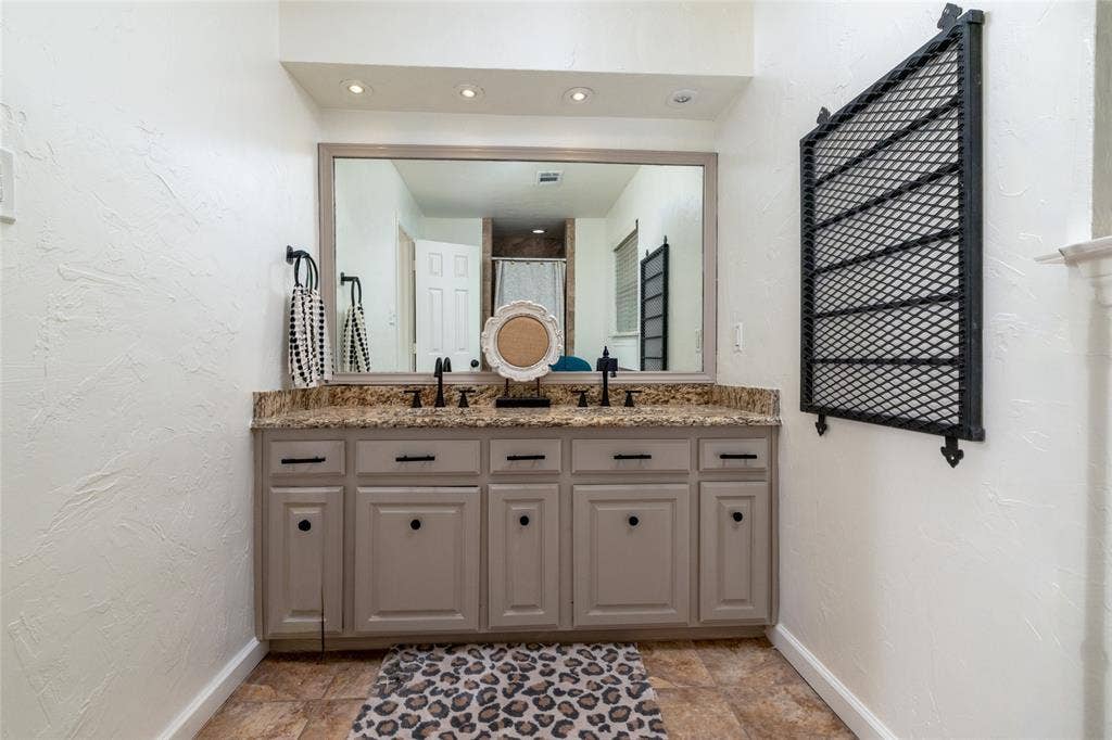 Double vanity with a granite countertop, dual undermount sinks, and matte black fixtures