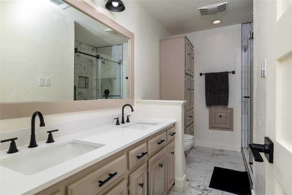 Double vanity with white countertops and matte black fixtures