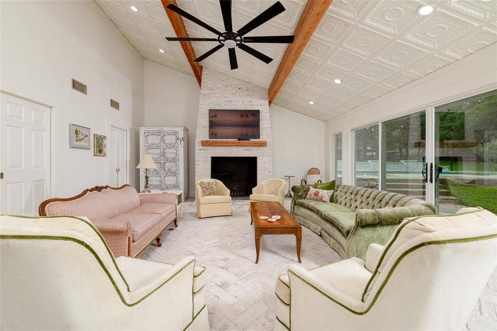 Spacious living area featuring a vaulted ceiling with decorative ceiling tiles, exposed wood beams, and recessed lighting