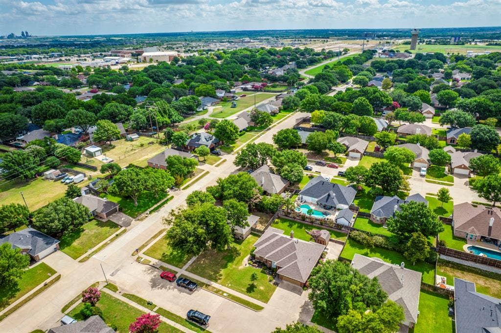 Aerial perspective showcasing a residential neighborhood with mature trees and a structured street layout