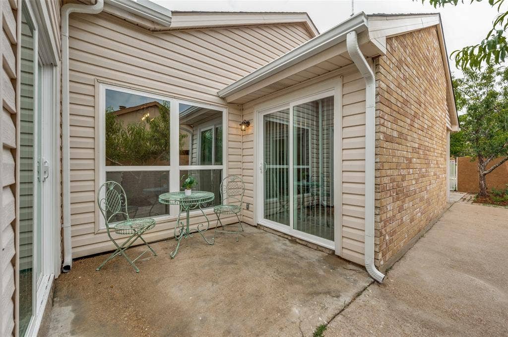 412 Pogue Street, Cedar Hill, TX 75104 Exterior patio featuring a concrete surface, a large sliding glass door, and a prominent window
