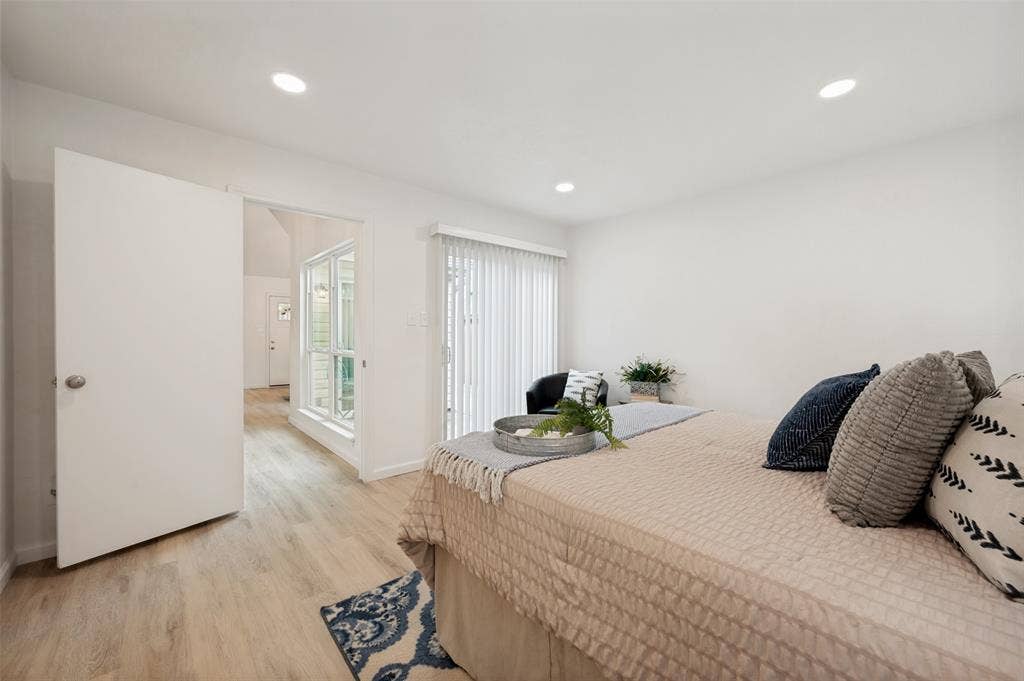 412 Pogue Street, Cedar Hill, TX 75104 Spacious room featuring light wood-finish flooring, recessed lighting, and a sliding glass door with vertical blinds