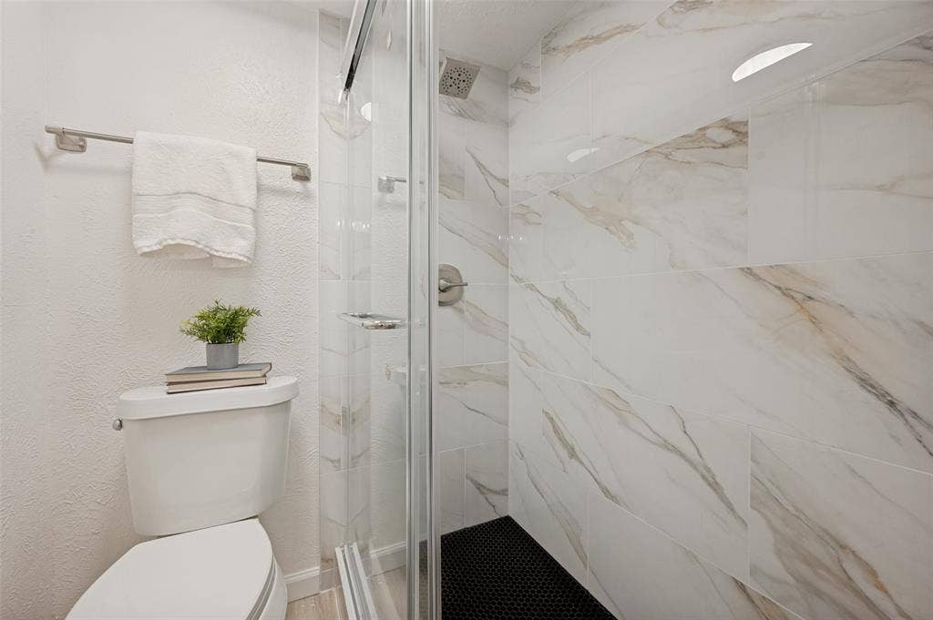 412 Pogue Street, Cedar Hill, TX 75104 Walk-in shower with clear glass enclosure and marble-look tile surround