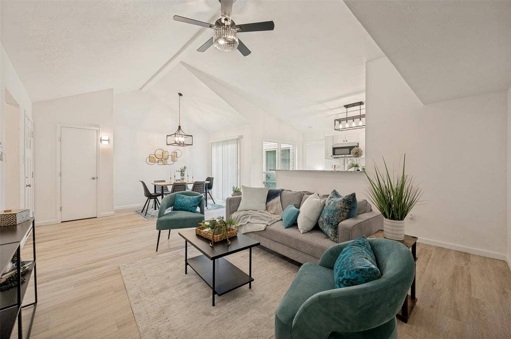 412 Pogue Street, Cedar Hill, TX 75104 Living area featuring vaulted ceilings with a ceiling fan, light wood-finish flooring, and a kitchen pass-through