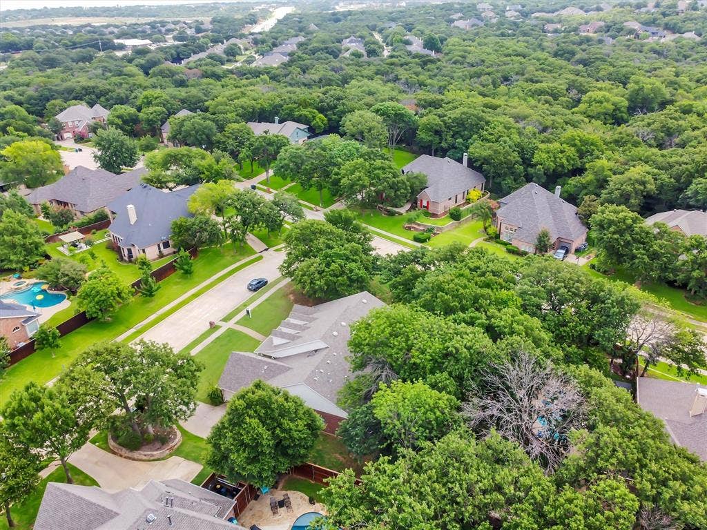 Aerial perspective showcasing a residential area with extensive tree coverage
