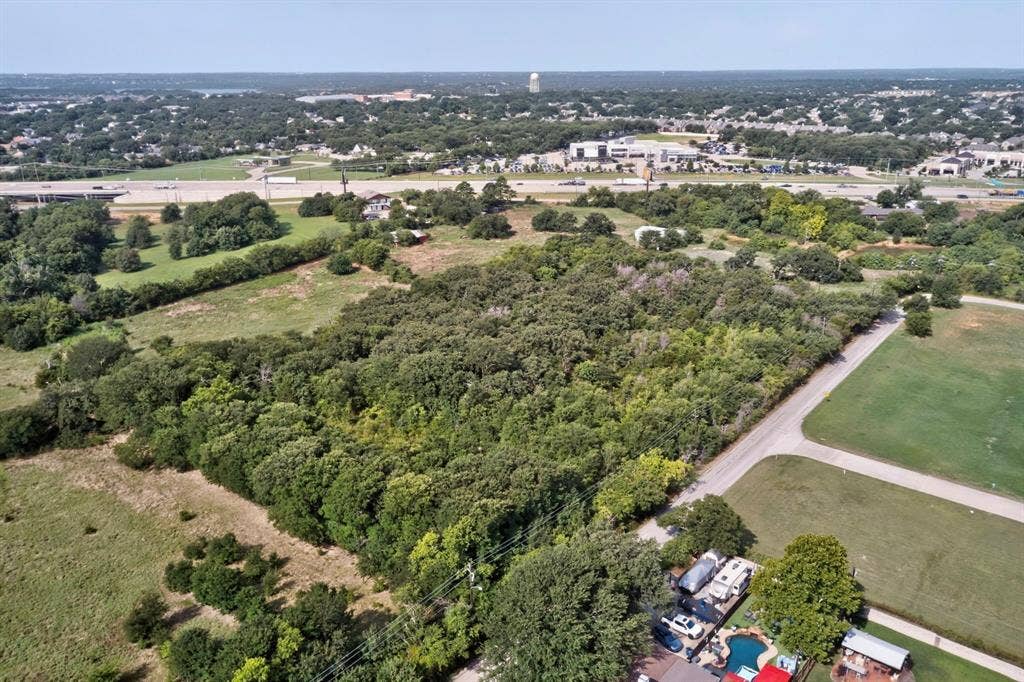 Expansive undeveloped land featuring a dense tree line and open grassy areas
