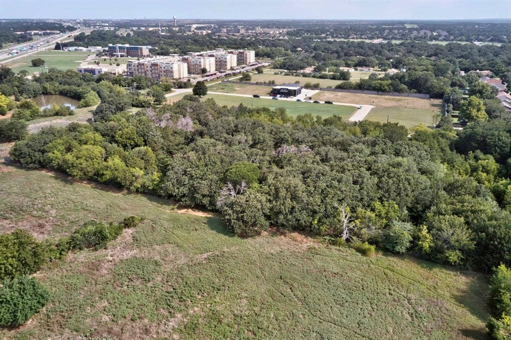 Expansive land parcel featuring mature trees and open grassy areas