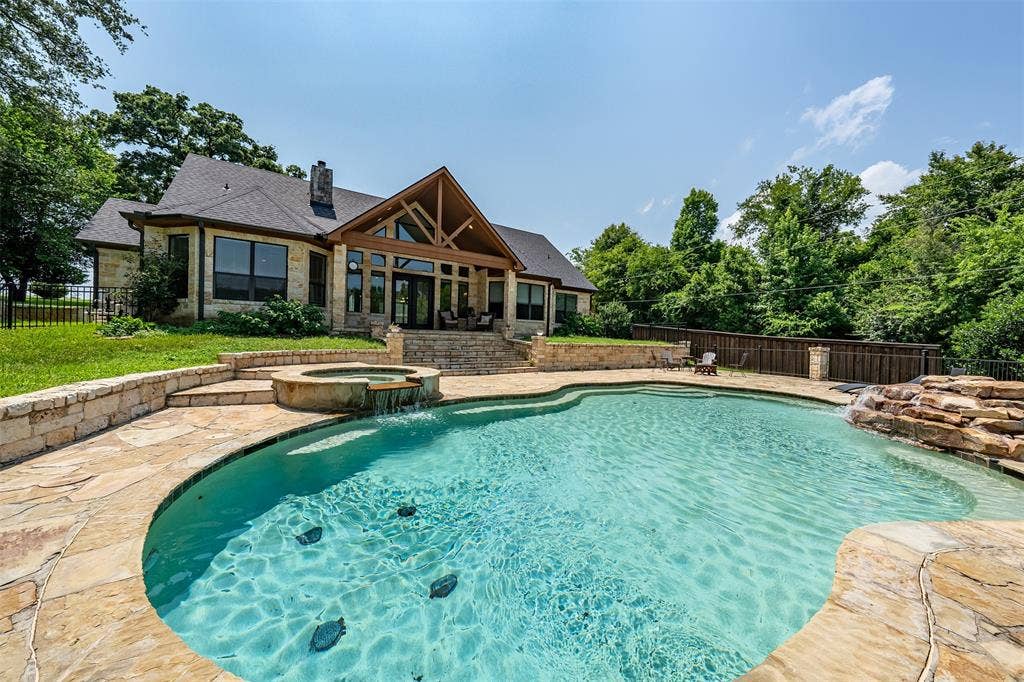 6414 Dorsey Drive, Athens, TX 75752 Expansive outdoor living area featuring a freeform swimming pool with a stone waterfall feature and integrated spa