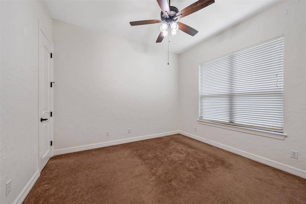 6414 Dorsey Drive, Athens, TX 75752 Interior room featuring neutral wall paint, brown carpeting, a window with horizontal blinds, and a ceiling fan with integrated lighting